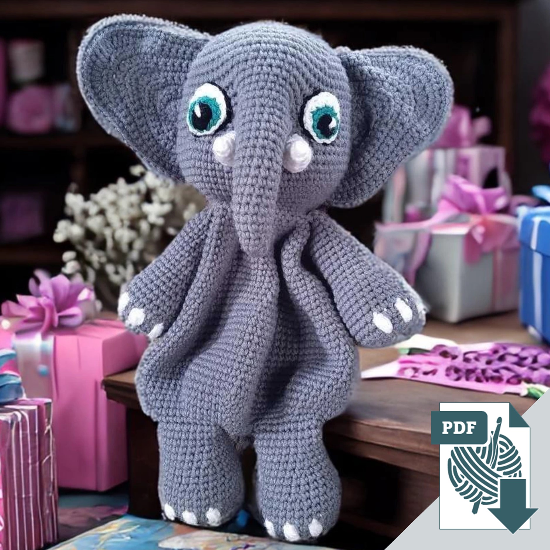 Crocheted elephant lovey sitting on a table surrounded by wrapped gifts, showcasing the finished result of a digital amigurumi crochet pattern.