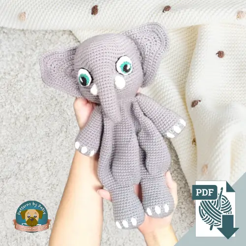 Crochet elephant lovey being held over a baby blanket, showcasing the finished result of a digital crochet elephant lovey pattern.